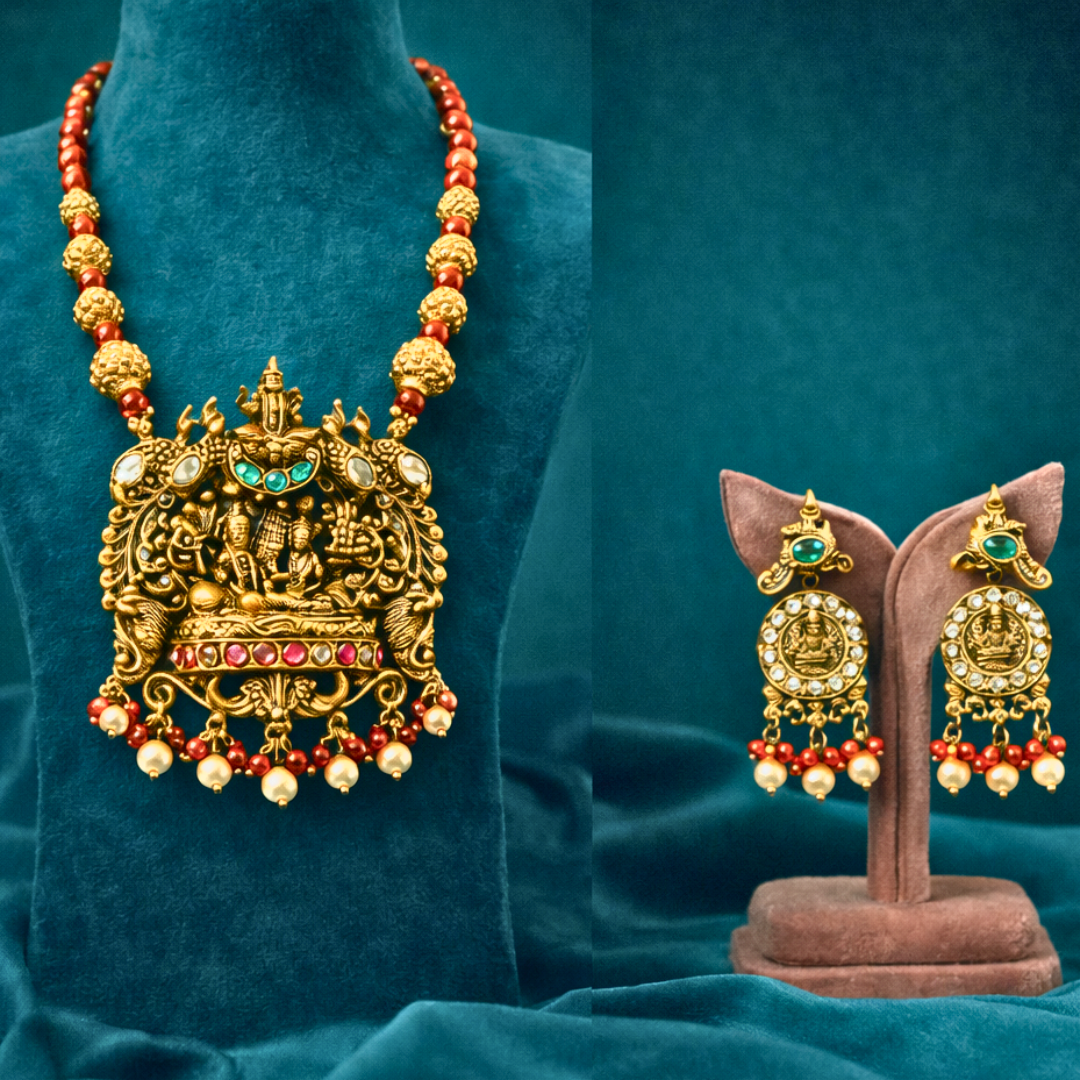 Gold necklace with red beads and matching earrings on a blue background